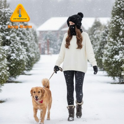 Woman wearing a knitted fleece lined balaclava as hooded beanie and neck warmer in snowy winter
