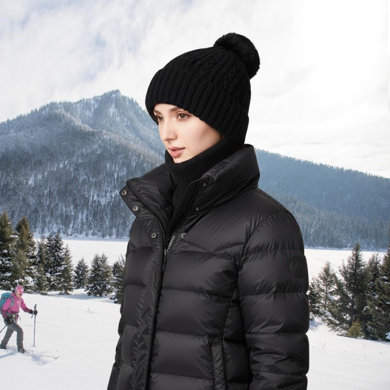 Woman wearing a knitted fleece lined balaclava as hooded beanie and neck warmer in snowy winter