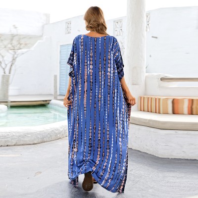 Blue Plus Size And Flowy Kaftan Dress – Women's Bohemian Beach Cover Up Woman in blue arrow and stripe pattern kaftan dress with batwing sleeves and V-neck on beach
