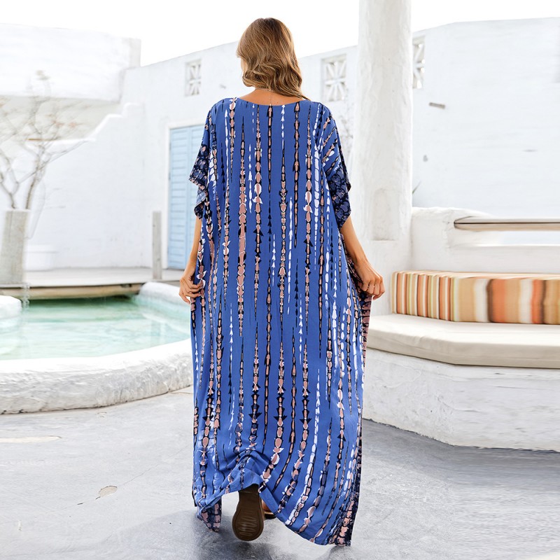 Blue Plus Size And Flowy Kaftan Dress – Women's Bohemian Beach Cover Up Woman in blue arrow and stripe pattern kaftan dress with batwing sleeves and V-neck on beach
