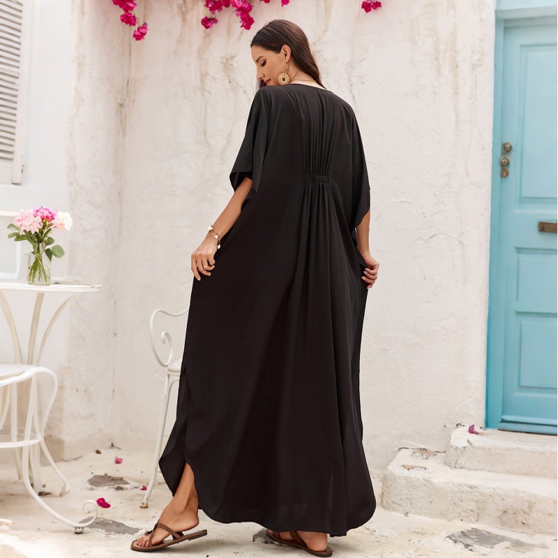 Plus Size Black Kaftan Dress - Resort Cover Up Woman in black kaftan dress with hat and straw bag at beach