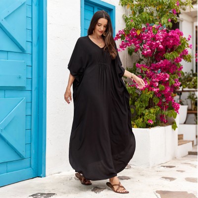 Plus Size Black Kaftan Dress - Resort Cover Up Woman in black kaftan dress with hat and straw bag at beach
