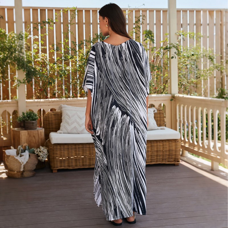 Bohemian Abstract Striped Caftan Dress: Women's Beach Cover Up Woman in bohemian abstract striped caftan dress with batwing sleeves and V-neck on beach