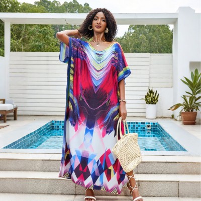 Colorful Tie-Dyed Kaftan Dress for Women Woman in colorful tie-dyed women's kaftan dress with V-neck and batwing sleeves by a pool