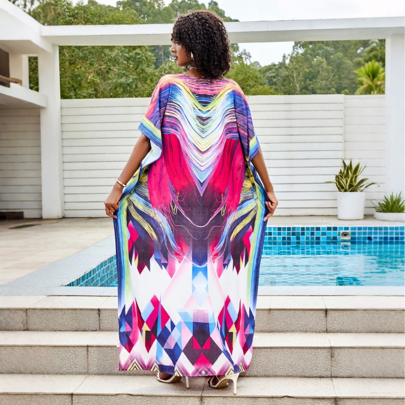 Colorful Tie-Dyed Kaftan Dress for Women Woman in colorful tie-dyed women's kaftan dress with V-neck and batwing sleeves by a pool