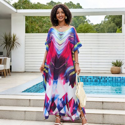 Colorful Tie-Dyed Kaftan Dress for Women Woman in colorful tie-dyed women's kaftan dress with V-neck and batwing sleeves by a pool
