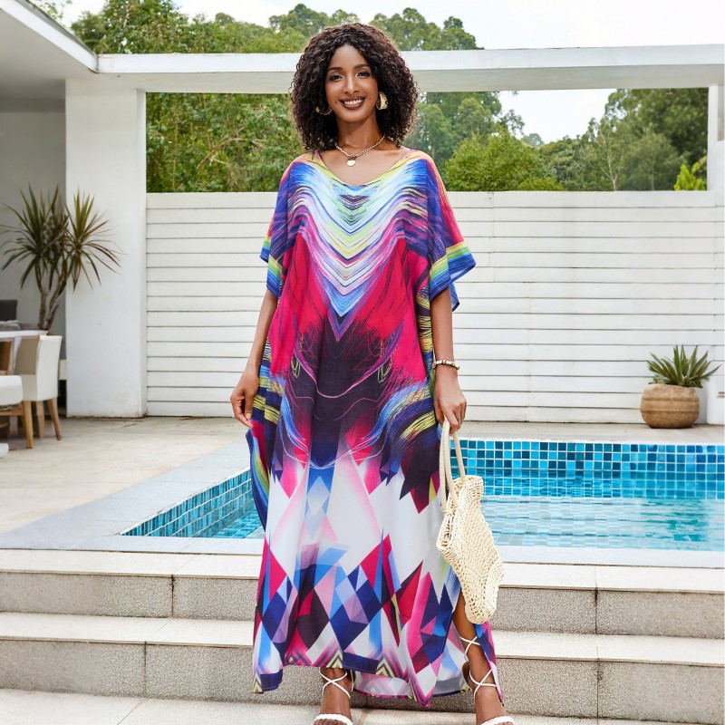 Colorful Tie-Dyed Kaftan Dress for Women Woman in colorful tie-dyed women's kaftan dress with V-neck and batwing sleeves by a pool