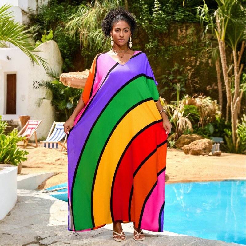 Plus Size Rainbow Stripe Kaftan Maxi Dress – Summer Beachwear Woman in a rainbow striped V neck kaftan maxi dress standing by a pool
