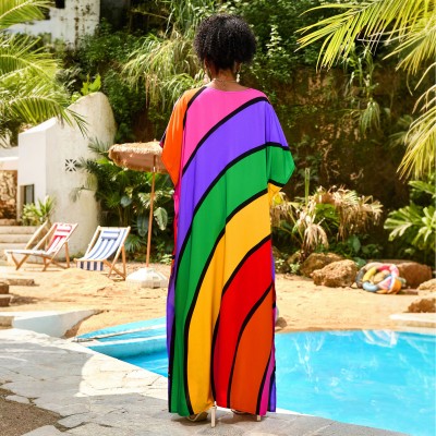 Plus Size Rainbow Stripe Kaftan Maxi Dress – Summer Beachwear Woman in a rainbow striped V neck kaftan maxi dress standing by a pool