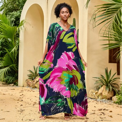 Woman wearing colorful bohemian V neck kaftan maxi dress by the pool   