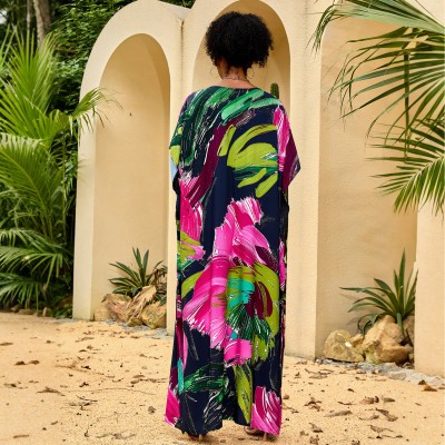 Woman wearing colorful bohemian V neck kaftan maxi dress by the pool   